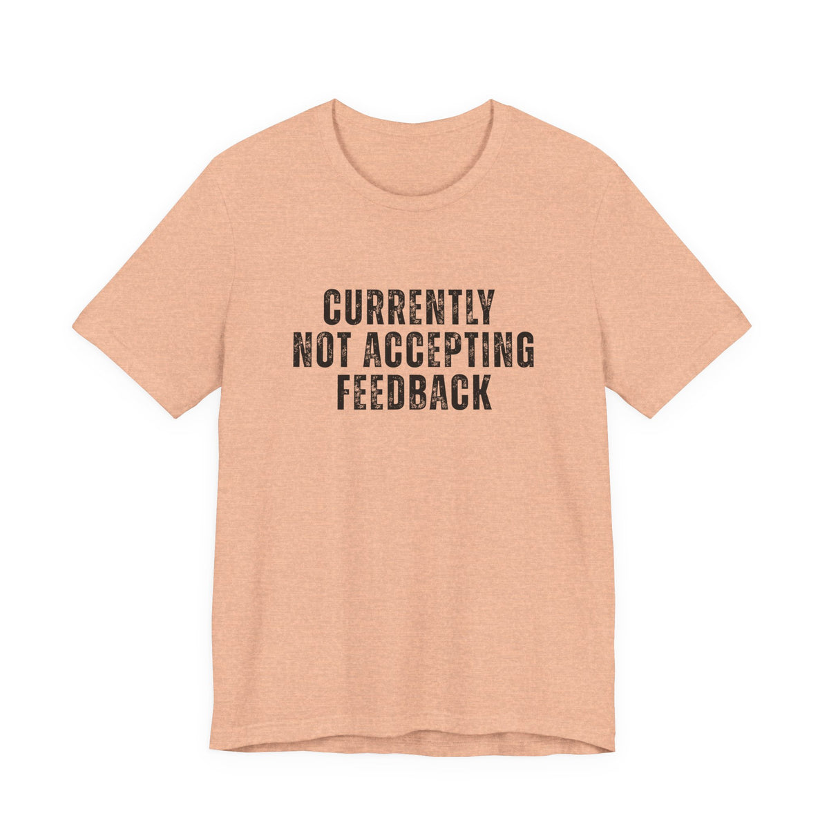 A peach-colored short-sleeve t-shirt with the text 'CURRENTLY NOT ACCEPTING FEEDBACK' printed in black distressed capital letters on the chest, displayed against a solid white background.