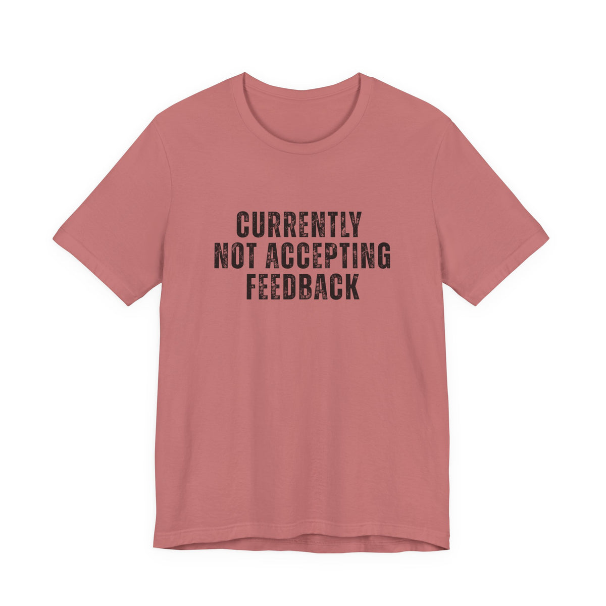 A dusty rose pink short-sleeve t-shirt with the text 'CURRENTLY NOT ACCEPTING FEEDBACK' printed in distressed black capital letters on the chest, displayed against a solid white background.