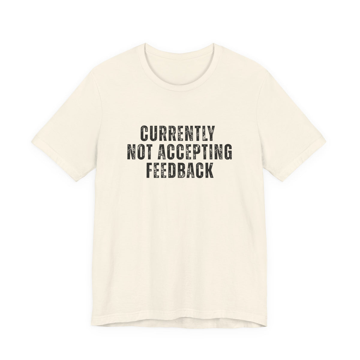 An off-white short-sleeve t-shirt with the text 'CURRENTLY NOT ACCEPTING FEEDBACK' printed in a distressed black font on the chest, displayed against a solid white background.