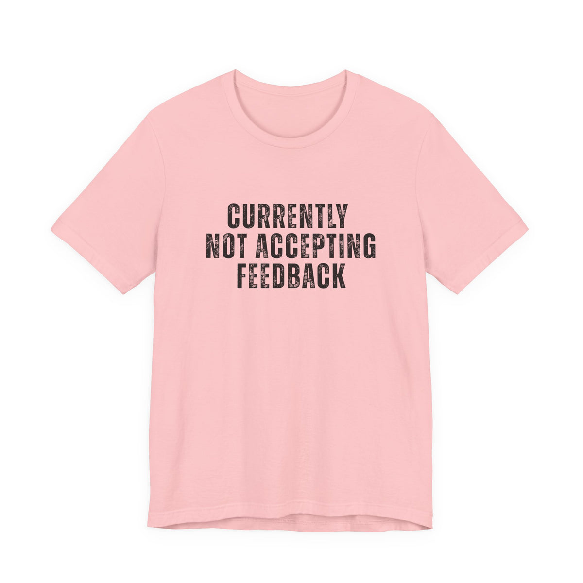 A light pink short-sleeve crewneck t-shirt with the text 'CURRENTLY NOT ACCEPTING FEEDBACK' printed in a distressed black font on the chest, displayed against a solid white background.
